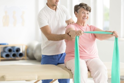healthcare worker helping a senior with physical therapy in a retirement community