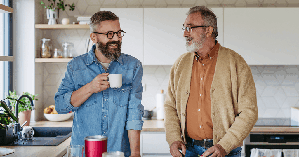 Two men share a moment over coffee in a cozy kitchen setting.