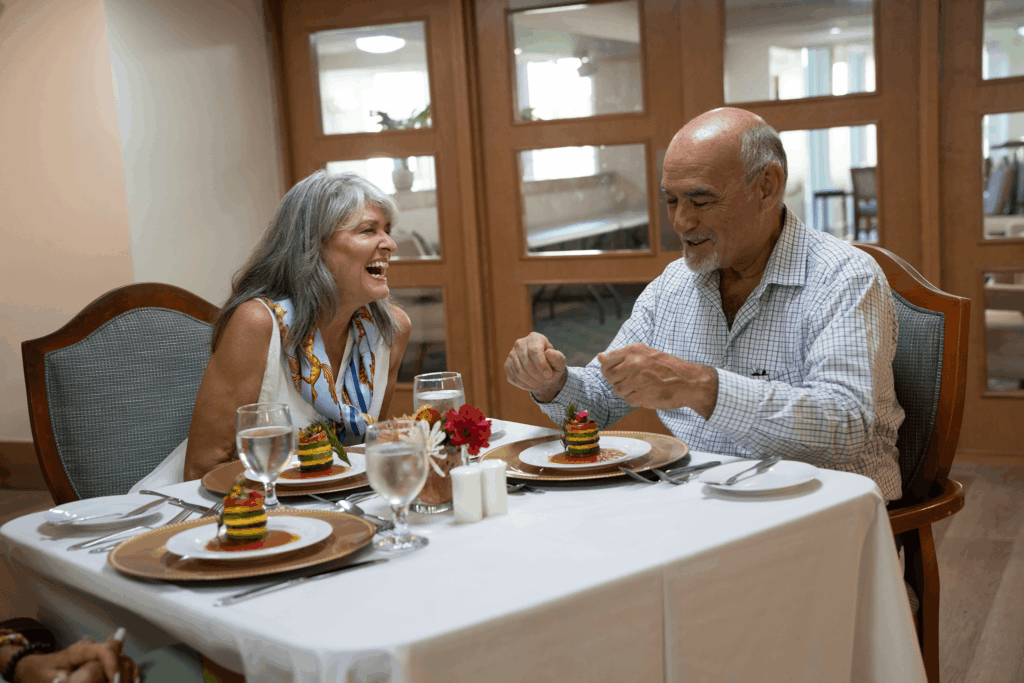 A couple enjoys dessert at an elegant table setting with white linens and glasses of water.
