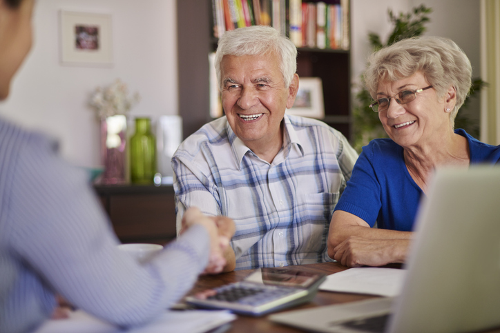 A senior man and a senior woman speaking with a realtor