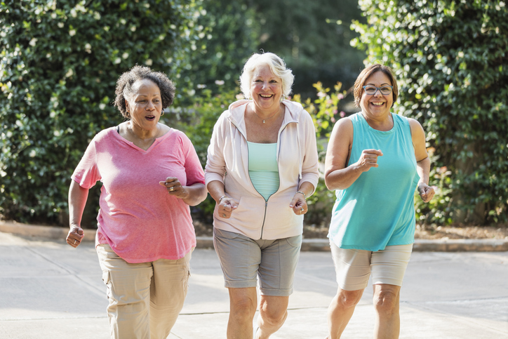 Older women exercising outdoors in summer.