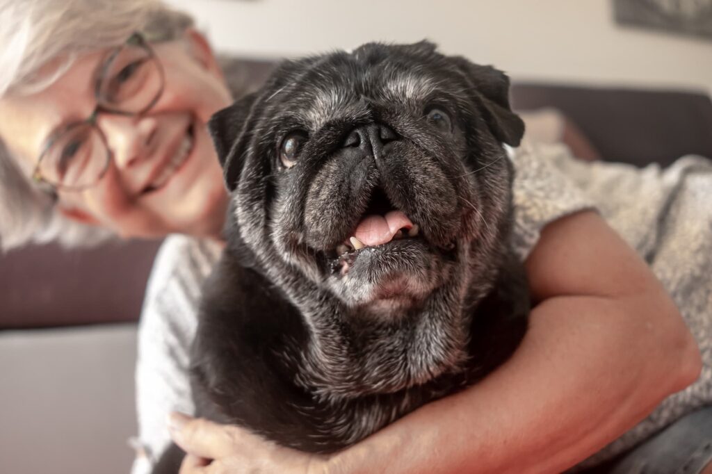 Senior woman with smiling black dog